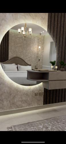 Schlafzimmer mit einem Bett und einem runden Spiegel in der Unterkunft برج داماك الجوهرة جدة - Damac al jawharah tower in Dschidda