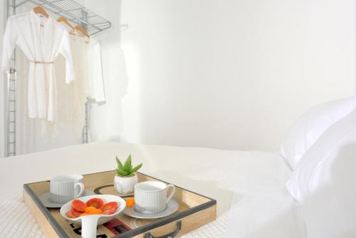 a tray with cups and bowls of fruit on a bed at Luxurious Villa Ostria in Elia Beach