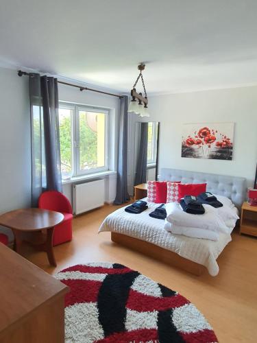 a bedroom with a bed with red and white pillows at Dom Gościnny Marta in Krynica Morska