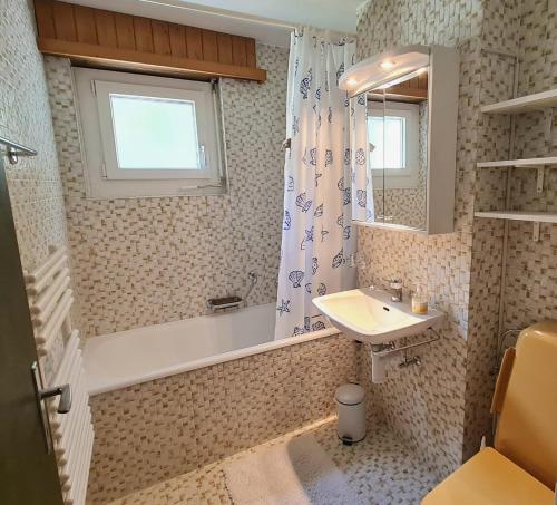 bagno con lavandino, specchio e doccia di Lorée 201 a Leukerbad