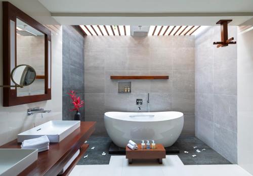 a bathroom with a white tub and a sink at Jetwing Saman Villas, A Luxury Reserve - Adults Only in Bentota