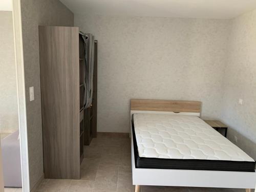 a small bedroom with a bed and a refrigerator at Résidence du Lac - Bourbon-Lancy in Bourbon-Lancy
