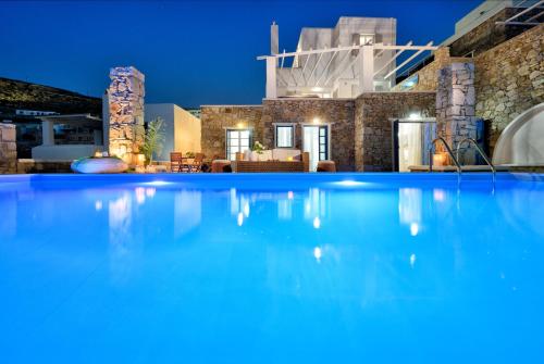 a large swimming pool in front of a house at night at Luxurious Villa Ostria in Elia Beach