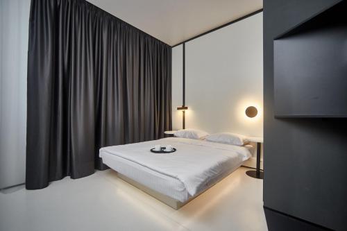 a bedroom with a white bed and black curtains at Sunday Rooms in Odesa
