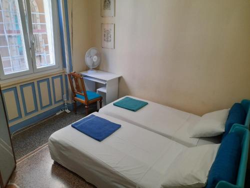 two beds in a room with a desk and a chair at Le Stanze del Notaio in Genova