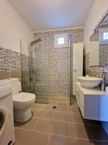 a bathroom with a toilet and a sink at Beachlife: The Bungalow in Kos