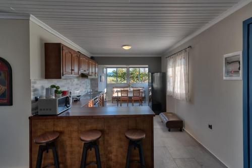 a kitchen with a counter and some stools in a room at Beachlife: The Bungalow in Kos Town