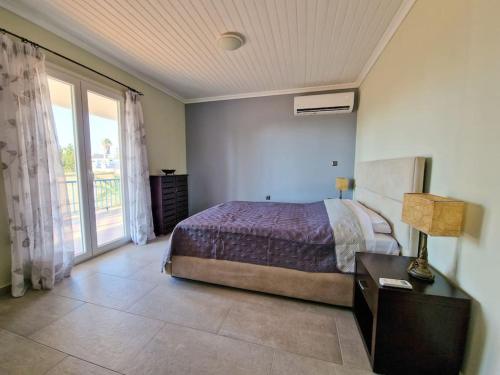 a bedroom with a bed and a large window at Beachlife: The Bungalow in Kos Town