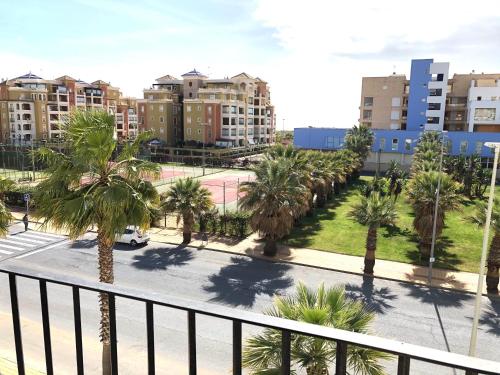 vistas a una calle con palmeras y edificios en Marina Isla Canela apartment, en Huelva