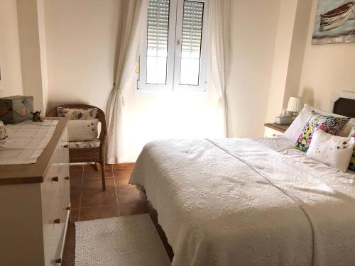 1 dormitorio con cama, escritorio y ventana en Marina Isla Canela apartment, en Huelva