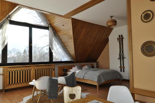 ein Schlafzimmer mit einem Bett und einem großen Fenster in der Unterkunft B&B Art House Szymaszkowa 1 in Zakopane