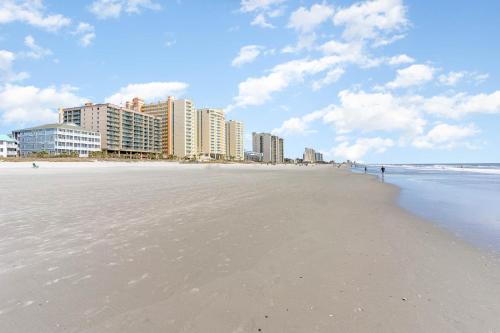 a view of the beach with buildings in the background at Spacious Penthouse Ocean Front 7 BR Condo - Ambassador Villas Unit 401 in Myrtle Beach