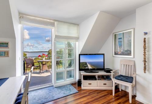 ein Wohnzimmer mit einem TV und einem großen Fenster in der Unterkunft Residenz am Balmer See - BS 62 mit Wellnessbereich in Balm