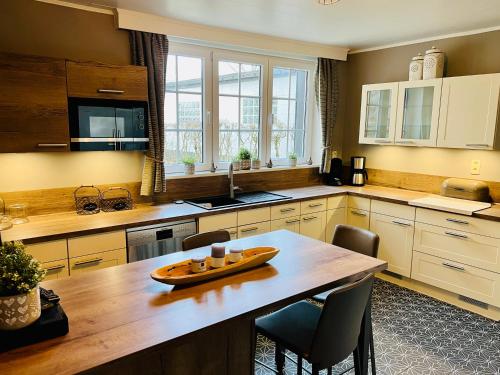 a large kitchen with a wooden table and chairs at La Dame du Lac in Waimes