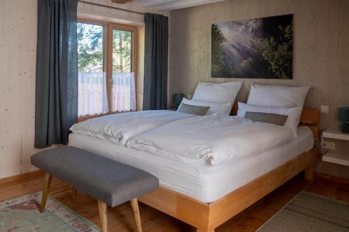 ein großes weißes Bett in einem Zimmer mit Fenster in der Unterkunft Servus Almtal in Scharnstein