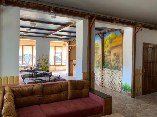 a living room with a couch and a painting on the wall at Гостьовий двір РіОНІ in Truskavets