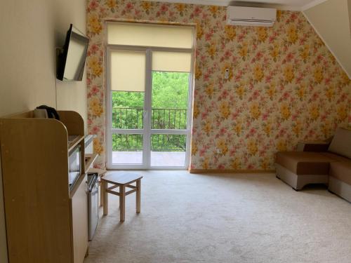 a living room with a window and a couch at Гостьовий двір РіОНІ in Truskavets