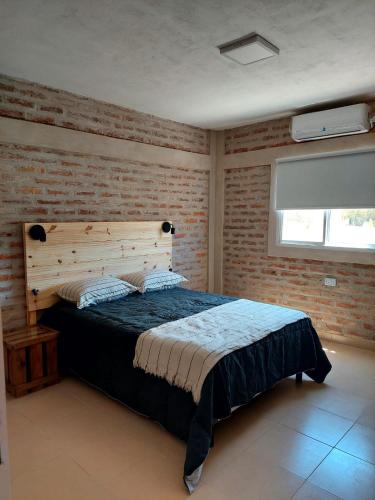 1 dormitorio con cama y pared de ladrillo en Salir del Cráter Apart in 