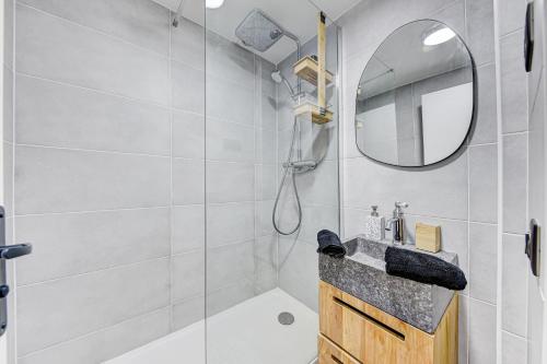 uma casa de banho com um chuveiro, um lavatório e um espelho. em PANTHEON em Paris