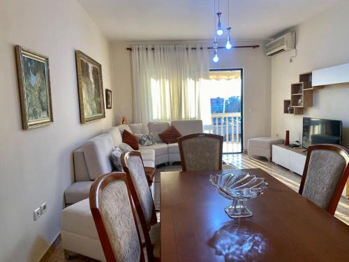 sala de estar con mesa de comedor y sofá en RTSH Apartment, en Tirana