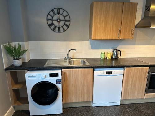 a kitchen with a washing machine and a sink at Stylish 2 Bed Apartment Derby in Derby