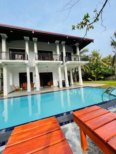 una piscina frente a una casa en sunset villa, en Hikkaduwa