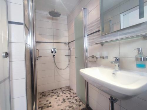 ein Bad mit einem Waschbecken und einer Dusche in der Unterkunft Gästehaus im Alten Fährhaus in Cochem