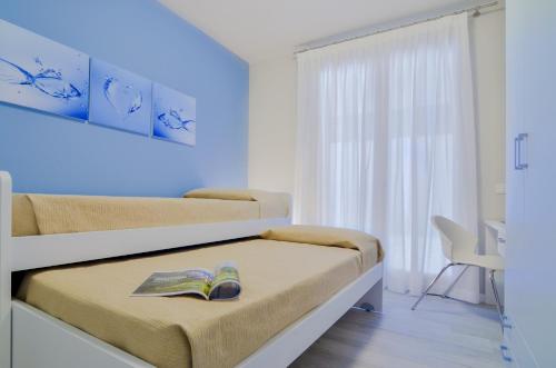 - une chambre avec 2 lits et un livre sur le lit dans l'établissement Domino Apt, à Sarnico