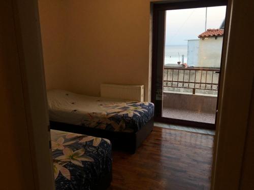 a room with two beds and a view of the ocean at Sea Sunset Appartment in Nea Iraklia