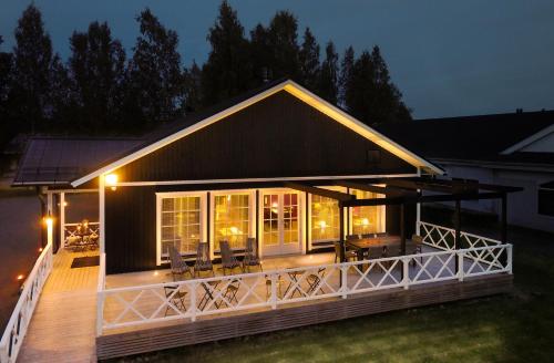 a house with a large deck at night at Hotelli HiljaHelena in Kurikka
