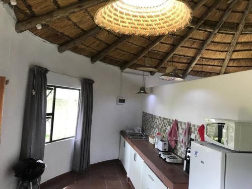 a kitchen with a refrigerator and a chandelier at The Rondavel @ Foundation Lodge in Sodwana Bay