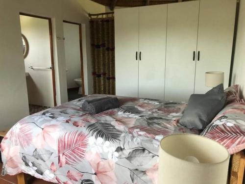 een slaapkamer met een bed met een kleurrijke deken bij The Rondavel @ Foundation Lodge in Sodwana Bay