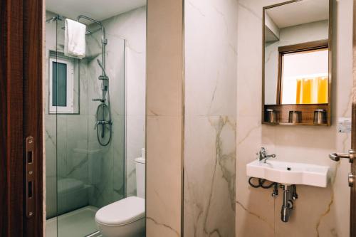 uma casa de banho com um WC, um lavatório e um chuveiro em Primera Hotel em St. Paul's Bay