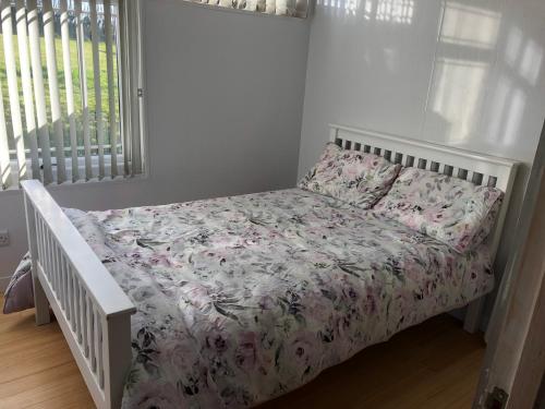 a bedroom with a bed with a floral bedspread at Happy Chalet in Pembrokeshire