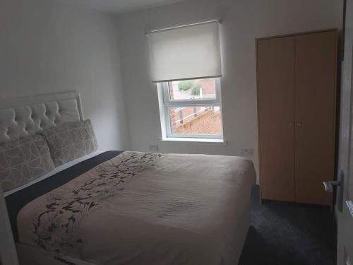 a white bedroom with a bed and a window at City, Celtic park & Emirates Stadium Apartment, for families or age over 23 in Glasgow