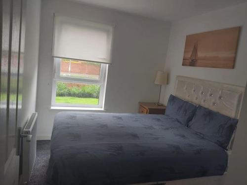 Un dormitorio con una cama grande y una ventana en City, Celtic park & Emirates Stadium Apartment, for families or age over 23 en Glasgow