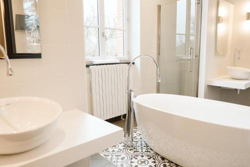 a white bathroom with a tub and a sink at Domaine d'En Fargou in Saint-Sulpice