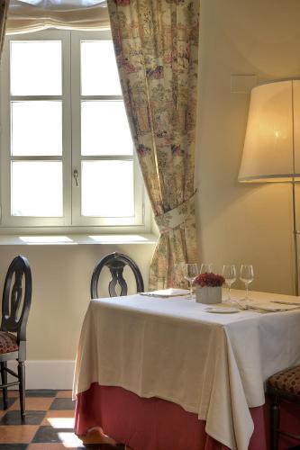 a table with wine glasses and a window at Hotel Palacio Urgoiti in Mungia
