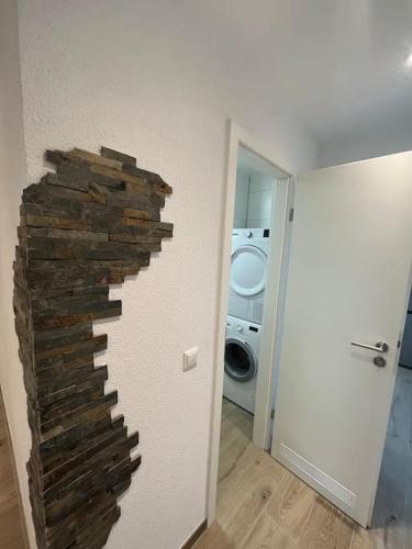 a brick wall in a room with a washing machine at Familienwohnung neben dem See,Messe und Europapark in Offenburg