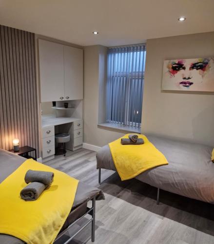 a bedroom with two beds with yellow sheets at Apartment in Uppermill in Saddleworth