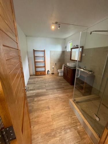 a bathroom with a shower and a toilet and a glass door at Top floor studio -Villa Ibiza in Trou d'Eau Douce