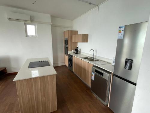 an empty kitchen with a sink and a refrigerator at Top floor studio -Villa Ibiza in Trou d'Eau Douce