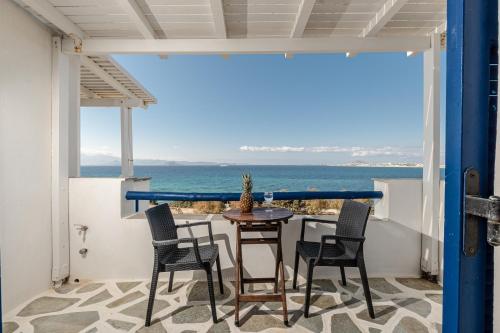 a patio with chairs and a table with a view of the ocean at Orkos View in Mikri Vigla