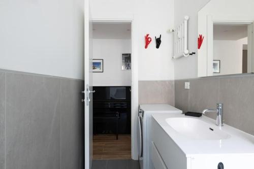 ein weißes Badezimmer mit einem Waschbecken und einem Spiegel in der Unterkunft HospitalityRome Casa Veronica in Rom