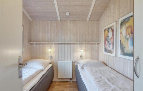 two beds in a room with wooden walls at Strandblick 16 in Schönhagen