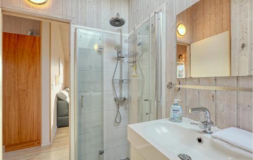 a white bathroom with a shower and a sink at Strandblick 16 in Schönhagen