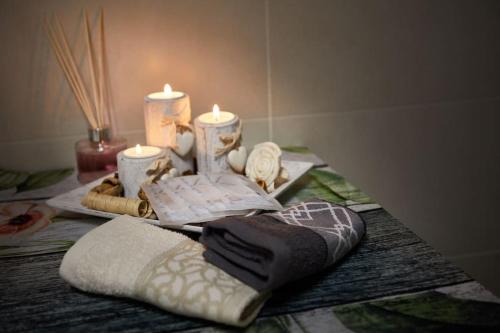 a table with towels and candles on a table at Center Aviano Comfort Suite FREE PARKING WIFI in Aviano