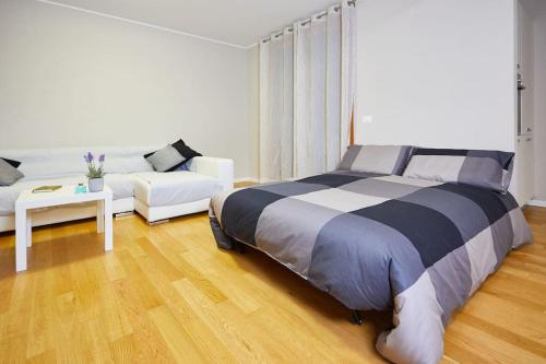 a bedroom with a large bed and a couch at Center Aviano Comfort Suite FREE PARKING WIFI in Aviano