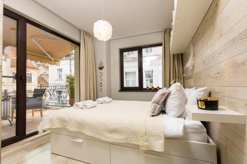 a bedroom with a large bed and a balcony at Luxury Central Apartment in Plovdiv