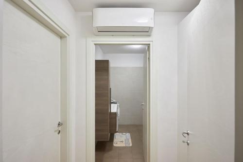 un pasillo con una puerta que conduce a un baño en Center Aviano Comfort Suite FREE PARKING WIFI, en Aviano